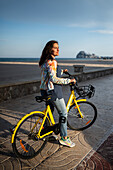 Frau fährt mit dem Fahrrad an der Promenade entlang, Peñiscola, Spanien