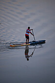 Standup paddleboarding at sunset in Ebro River, Zaragoza, Spain