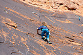 Ein 6-jähriger Junge lernt im Hunter Canyon in der Nähe von Moab, Utah, das Klettern.