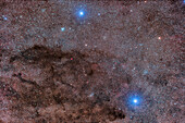 This frames the dark Coal Sack nebula in Crux, the Southern Cross, here recorded as multiple dark lanes, though to the eye the Coal Sack appears as one solid dark region in the Milky Way. The bright star at bottom is Acrux, or Alpha Cruxis, while the star at top is Becrux, or Beta Cruxis. Acrux is a superb double star in a telescope but it is not resolved here at this scale.