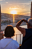 Ein Paar genießt den Blick auf den Sonnenuntergang von der Stadtmauer der Burg Papa Luna in Peñiscola, Castellon, Valencianische Gemeinschaft, Spanien