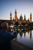 Besucher fotografieren die Kathedrale-Basilika Unserer Lieben Frau von der Säule bei Sonnenuntergang, Zaragoza, Spanien