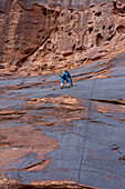 Ein 6-jähriger Junge lernt im Hunter Canyon in der Nähe von Moab, Utah, das Klettern.