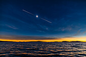 Dies ist die Sequenz der totalen Sonnenfinsternis über den Gewässern des Lac Brome in den Eastern Townships von Quebec, Kanada, am 8. April 2024. Auf die Einzelaufnahme der total verfinsterten Sonne am verdunkelten Finsternishimmel habe ich Bilder der partiellen Phasen vor und nach der Totalität gelegt, die alle 5 Minuten vom Beginn bis zum Ende der Finsternis aufgenommen wurden. Während sich die Sonne von links nach rechts über den Himmel bewegte, bewegte sich der Mond von rechts nach links über die Sonnenscheibe.