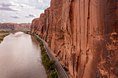 Luftaufnahme der Wingate Cliffs am Highway 279 entlang des Colorado River bei Moab, Utah. Beachten Sie die geparkten Fahrzeuge der Felskletterer entlang der Wall Street.