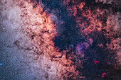 This frames the rich area surrounding the Galactic Centre, which is located at top centre here amid the dark lane of dust and above a small diffuse area of red nebulosity. To the left is the bright Sagittarius Starcloud, which contrasts with the dark lane that runs down the Milky Way. Nowhere else is there such a stark and sharp contrast between bright starclouds and dark lanes of dust. The star clouds show the yellowing effect of interstellar dust absorbing star light and reddening it.