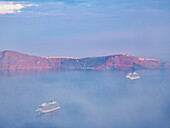 Caldera bei nebligem Sonnenaufgang von Fira aus gesehen, Insel Santorin (Thira), Kykladen, Griechische Inseln, Griechenland, Europa