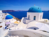 Ikonische blaue Kuppelkirchen der Auferstehung des Herrn und des Heiligen Spyridon, Dorf Oia, Insel Santorin (Thira), Kykladen, Griechische Inseln, Griechenland, Europa