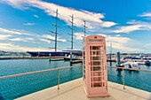 Eine alte britische Telefonzelle, hinter der ein dreimastiges Segelschiff vertäut ist, Hamilton, Bermuda, Nordatlantik, Nordamerika