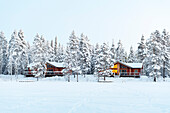 Winter view of a mountain lodge surrounded by frozen forest covered with snow in Swedish Lapland, Sweden, Scandinavia, Europe