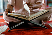 Muslim man sitting reading the Quran (Koran) the holy book of Islam, Mubarak Mosque, Chau Doc, Vietnam, Indochina, Southeast Asia, Asia