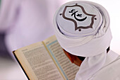 Muslim man reading an Arabic Holy Quran (Koran), Jamiul Azhar mosque, Vietnam, Indochina, Southeast Asia, Asia