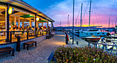 Blick auf den goldenen Sonnenuntergang, Boote und Restaurants an der Knysna Waterfront, Knysna, Westliche Kap-Provinz, Südafrika, Afrika