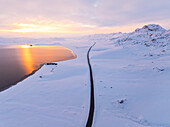 Luftaufnahme der Straße entlang des Kleifarvatn-Sees während eines herrlichen Wintersonnenuntergangs, Island, Polarregionen