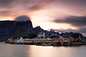 Eine Langzeitbelichtung, um das warme Licht des Sonnenuntergangs in Sakrisoy einzufangen, während eines Herbsttages, Reine, Moskenesoya, Lofoten Inseln, Nordland, Norwegen, Skandinavien, Europa