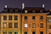 Night low angle view of traditional low-rise roof-tiled houses with facade decorations in the Old Town Market Place (Rynek Starego Miastra), Warsaw, Poland, Europe