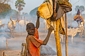 Mundari boy drumming to call back the cows, Mundari tribe, South Sudan, Africa