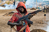 Junger Junge posiert mit Kalaschnikow, Mundari-Stamm, Südsudan, Afrika