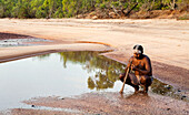 Aborigine-Yolngu-Mann mit Stammesfarbe aus Ton, die für Welcome to Country verwendet wird, in Nyinyikay Homeland, Ost Arnhem Land, Northern Territory, Australien, Pazifik