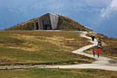 Italy, autonomous province of Bolzano, Val Pusteria, hikers on a trail accessing the Messner mountain museum, futuristic museum signed Zaha Hadid perched on top of a mountain and dedicated to mountaineer and mountaineer reinhold Messner