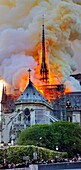 France, Paris, area listed as World Heritage by UNESCO, Notre Dame Cathedral of 14th century Gothic architecture during the fire of 15th April 2019, fire spreading in the arrow the frame of the transept and the roof of the nave, thick yellow smoke coming from the burning of the lead roof