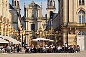 Frankreich, Meurthe und Mosel, Nancy, Place Stanislas (ehemaliger Place Royale) erbaut von Stanislas Leszczynski, König von Polen und letzter Herzog von Lothringen im achtzehnten Jahrhundert, klassifiziert als Welterbe der UNESCO, Terrasse des Hotel-Cafés Le Grand Hôtel mit der Kathedrale Notre-Dame-de-l'Annonciation