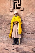 Äthiopien, Amhara-Region, Lalibela, Monolithische Kirche Bet Maryam, die zum UNESCO-Weltkulturerbe gehört, Priester vor einem Fenster in Form einer Swatiska