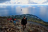 Italy, Sicily, Aeolian Islands, listed as World Heritage by UNESCO, Stromboli island, hikers climbing the volcano, the village of Stromboli and the islet of Strombolicchio in the background