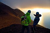 Italien, Sizilien, Äolische Inseln, von der UNESCO zum Weltnaturerbe erklärt, Insel Stromboli, Wanderer beobachten die Fumarolen an den Hängen des aktiven Vulkans bei Sonnenuntergang