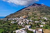 Italien, Sizilien, Äolische Inseln, von der UNESCO zum Weltkulturerbe erklärt, Insel Stromboli, der aktive Vulkan Stromboli über dem Dorf (Luftaufnahme)