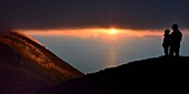 Italien, Sizilien, Äolische Inseln, von der UNESCO zum Weltnaturerbe erklärt, Insel Stromboli, Wanderer beobachten die Fumarolen an den Hängen des aktiven Vulkans bei Sonnenuntergang