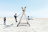 Marocco, Oued Ed-Dahab, Dakhla, Dakhla Attitude Resort, teens on swings on a beach at low tide