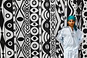 Marocco, Oued Ed-Dahab, Dakhla, Les Dunes Eco-lodge, young Moroccan in traditional clothes in front of a tent decorated with African tribal patterns