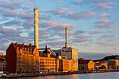 Sweden, Vastra Gotaland, Goteborg (Gothenburg), view of the thermal power plant of the city and the Affarshuset Merkur who is the oldest remaining house on Skeppsbron