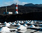 Spain, Canary Islands, La Palma, view of a lighthouse and saline that surround it by the sea, on a volcanic island