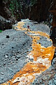 Spanien, Kanarische Inseln, La Palma, Wanderer in einem ausgetrockneten Canyon in einer bergigen und vulkanischen Umgebung