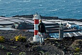 Spain, Canary Islands, La Palma, hiker on a path by the sea, near a lighthouse surrounded by salt