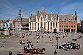 Belgium, West Flanders, Bruges, historical center listed as a UNESCO World Heritage, Grand Place, Provinciaal Hof or provincial palace, the historium museum and statue of Jan Breydel and Pieter de Coninck who headed the Bruges Mornings of 1302 massacring supporters of the King of France, passage of a carriage