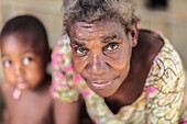 Cameroon, South Region, Ocean Department, Bagyeli village, portrait of a pygmy woman with a child in the background, village near the Lobe River