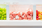 Assorted candy in clear dispensers, featuring watermelon slices at center stage