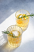 From above summer cocktail vodka with tonic and ripe kumquat fruit slices in the glass on stone table