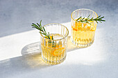 Summer cocktail vodka with tonic and ripe kumquat fruit slices in the glass on stone table