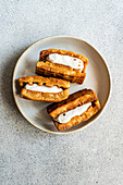 Stack of golden homemade waffles with creamy vanilla marshmallow filling served on a ceramic plate with a textured background