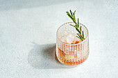 Top view of elegantly presented vodka tonic with a twist of grapefruit and a sprig of rosemary, symbolizing sophisticated refreshment