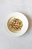 A top view image showing roasted radishes arranged on a white plate with a drizzle of green tahini sauce, garnished with parsley.