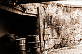 Old, Decomissioned & Obsolete Oil Drums, stacked away in a driveway for waste disposal inside the former DDR town of Chemnitz, just after Die Wende 1991. Shot on Analog Black & White Film. Former Karl Marx Stadt, Germany.