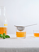 A bottle of homemade fruit-flavoured fermented kombucha drink on a white background