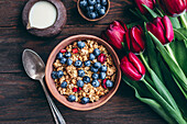 Granola with cherries and blueberries in a ceramic bowl