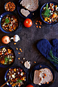 Schalen mit Minestrone nach sardischer Art, serviert mit Sauerteigbrot. Flatlay von oben nach unten mit negativem Raum.