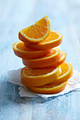 Freshly cut orange slices stacked on a blue background